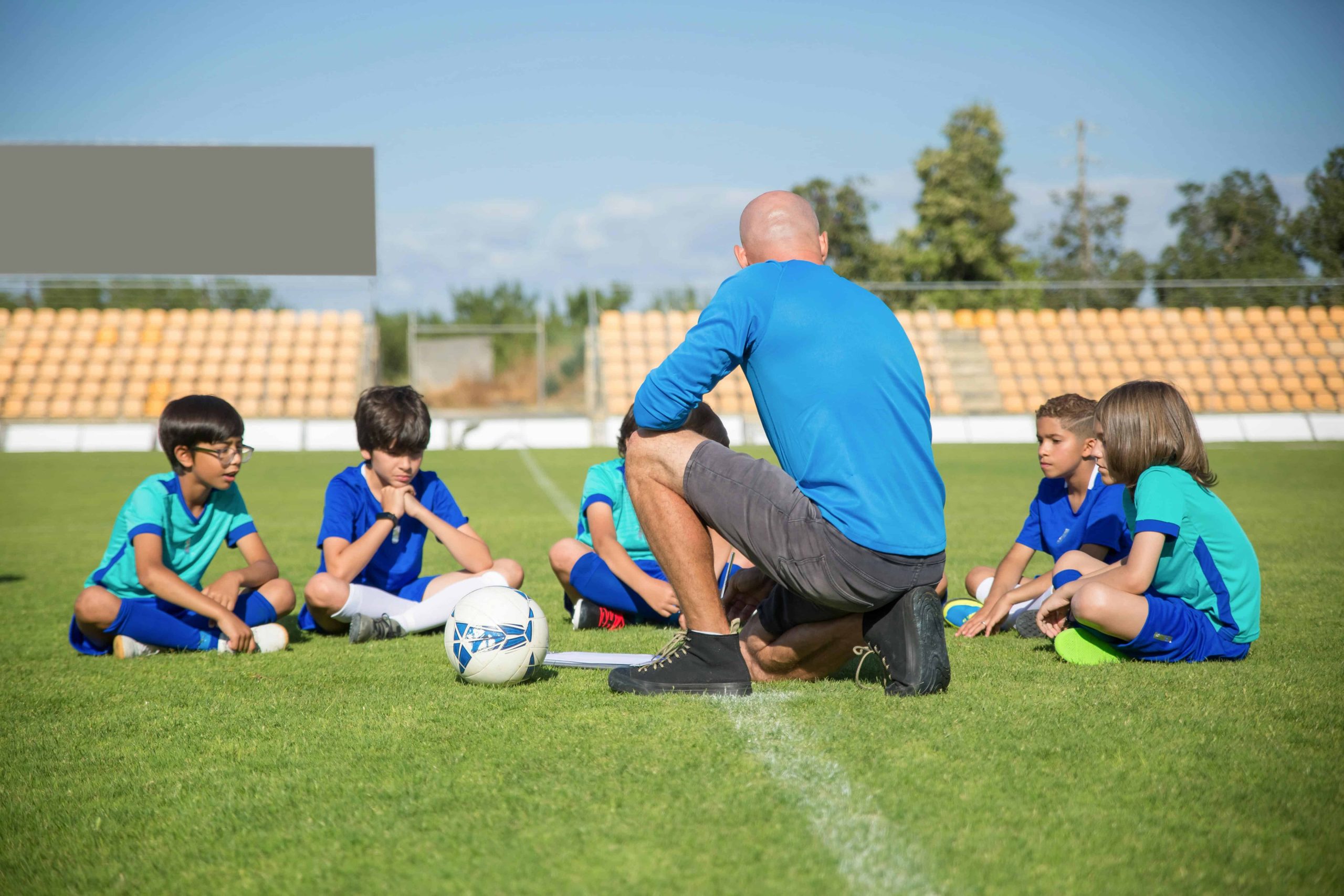 Coach high-fiving young athletes after practice, representing successful sports club member retention.